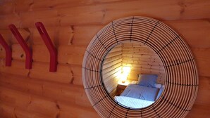 A circular window with a wooden interior and a bed visible through it. - Chalet - La Tzoumaz Verbier - on the slopes (La Tzoumaz)