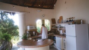 Una cucina con isola centrale, elettrodomestici bianchi e una persona in piedi al bancone.