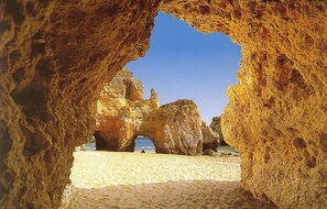 Ein Strand mit großen Felsformationen und freiem Blick auf das Meer.