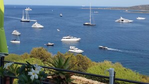 A balcony with a view of the sea, featuring several yachts and boats.