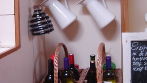 A wine rack with bottles and glasses, a chalkboard with writing, and wicker baskets.