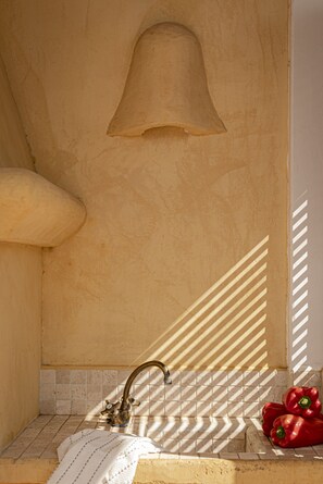 A bathroom with a vintage-style sink, a decorative wall-mounted object, and a tiled backsplash.