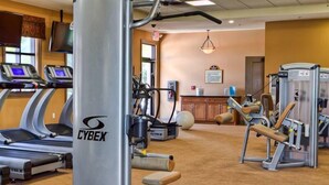 Un gimnasio con cintas de correr, máquinas de pesas y una elíptica Cybex.