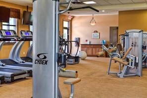 Ein Fitnessraum mit Laufbändern, Kraftgeräten und einem Cybex-Ellipsentrainer.
