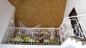 A staircase with a wooden handrail and a white railing with bird designs.