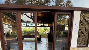 A building entrance with glass doors, a stone floor, and a bench. - 5-star. Rave reviews. Stunning lanai with ocean & mountain views. Special rates! (Ko Olina)