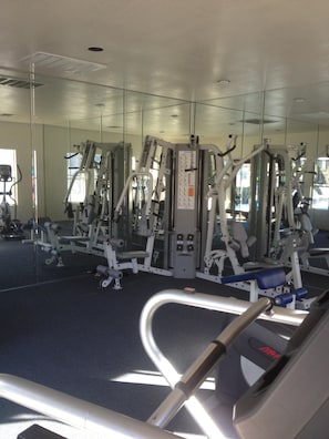 A gym with various exercise machines, a mirrored wall, and a blue carpeted floor. - Del Mar Heights Hideway w/ BBQ, Pool access, 5min drive to Beaches, 20min to Zoo (San Diego)