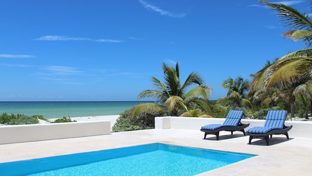 A poolside area with two lounge chairs and a view of the ocean. - BEROCO Front Beach House Yucatan Wi-Fi, Pool, Smart Tv (Uaymitun)