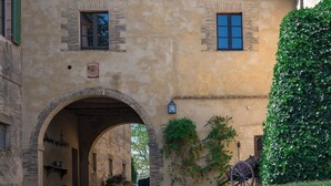 A historic building with an arched entrance, a clock, and a carriage. - Luxury Ecofriendly Country Villa  - Val d'orcia (Buonconvento Siena)