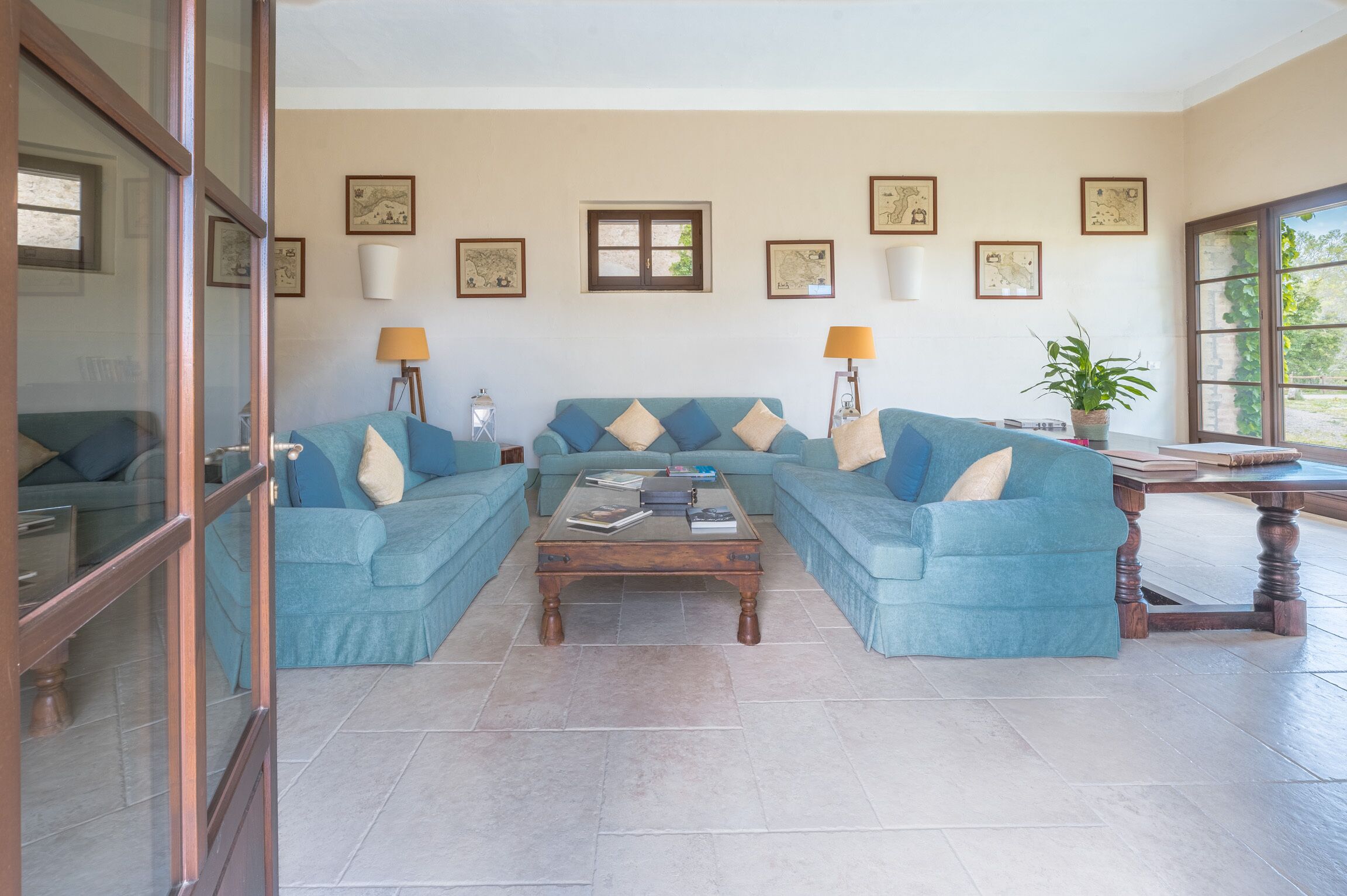 A living room with a sectional sofa, a coffee table, and wall-mounted lamps.