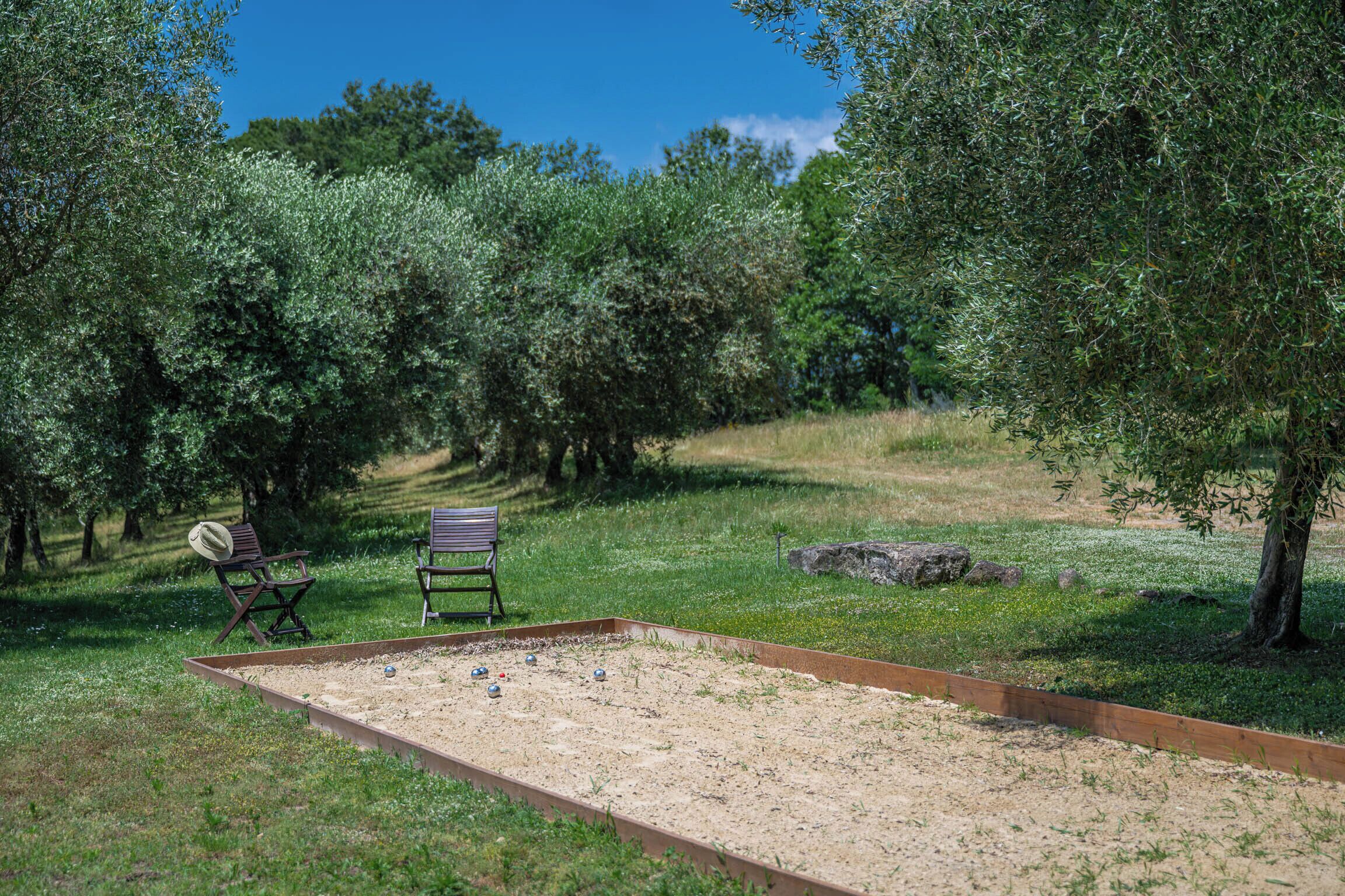 Un campo de croquet al aire libre con dos sillas y un tablero de juego.