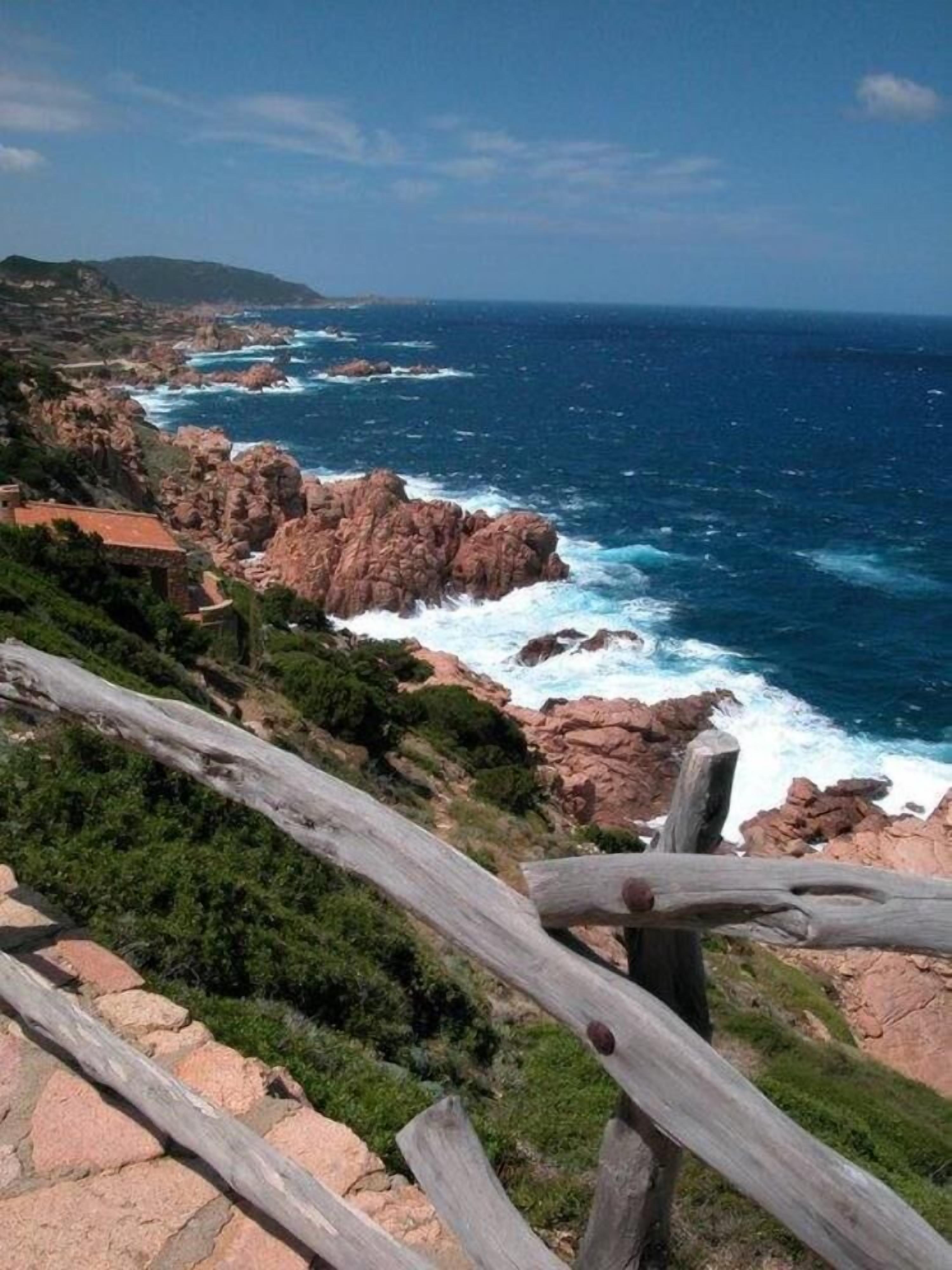 A coastal landscape with rocky terrain and a view of the ocean.