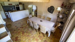 Un comedor con una mesa y sillas, una cocina al fondo y una decoración con forma de corazón en la pared.