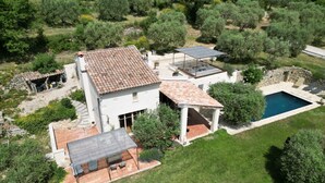 Vista aérea de una casa con techo de tejas, piscina y zona de patio.