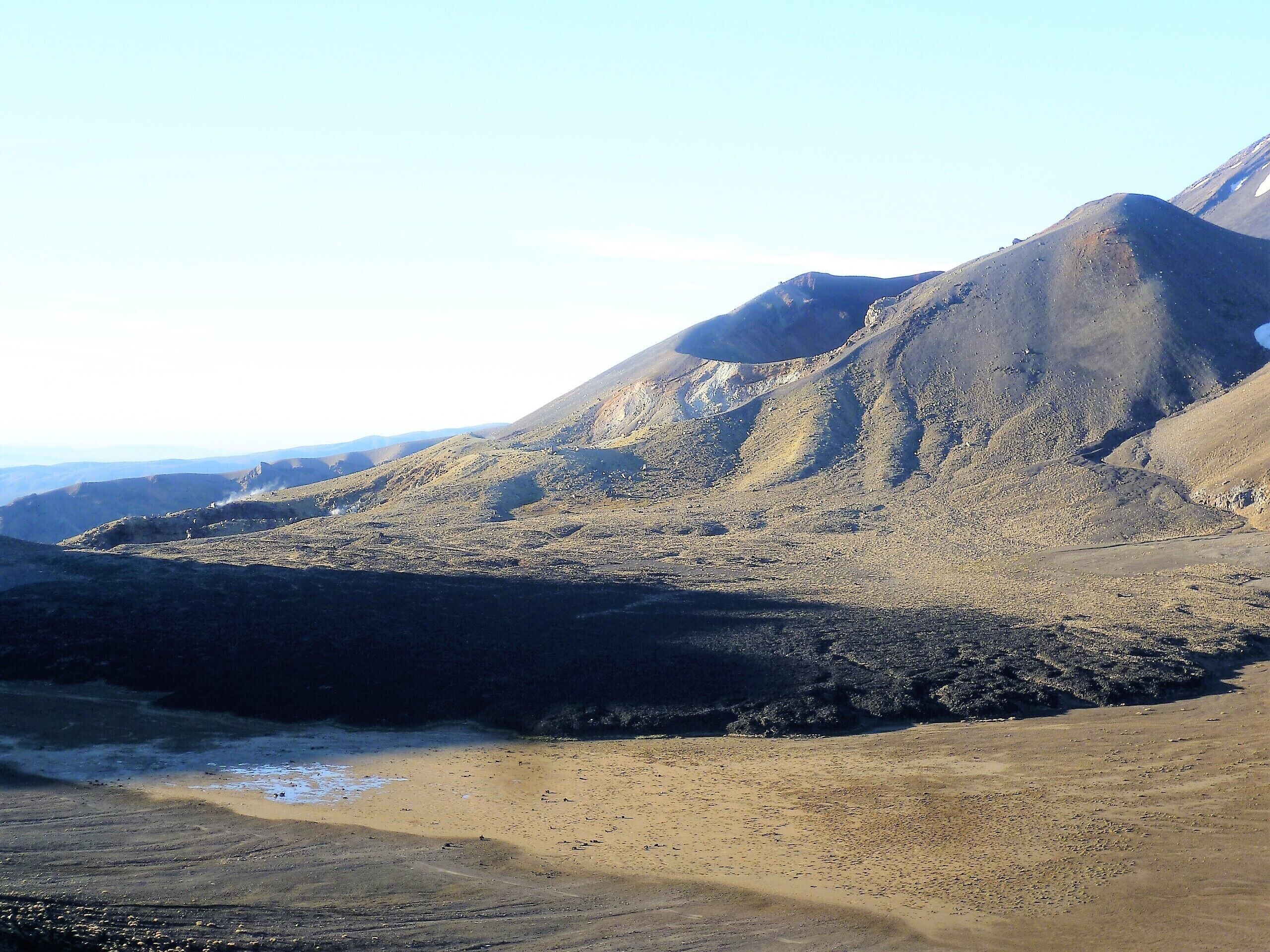 A rugged mountainous landscape with a sandy beach area.
