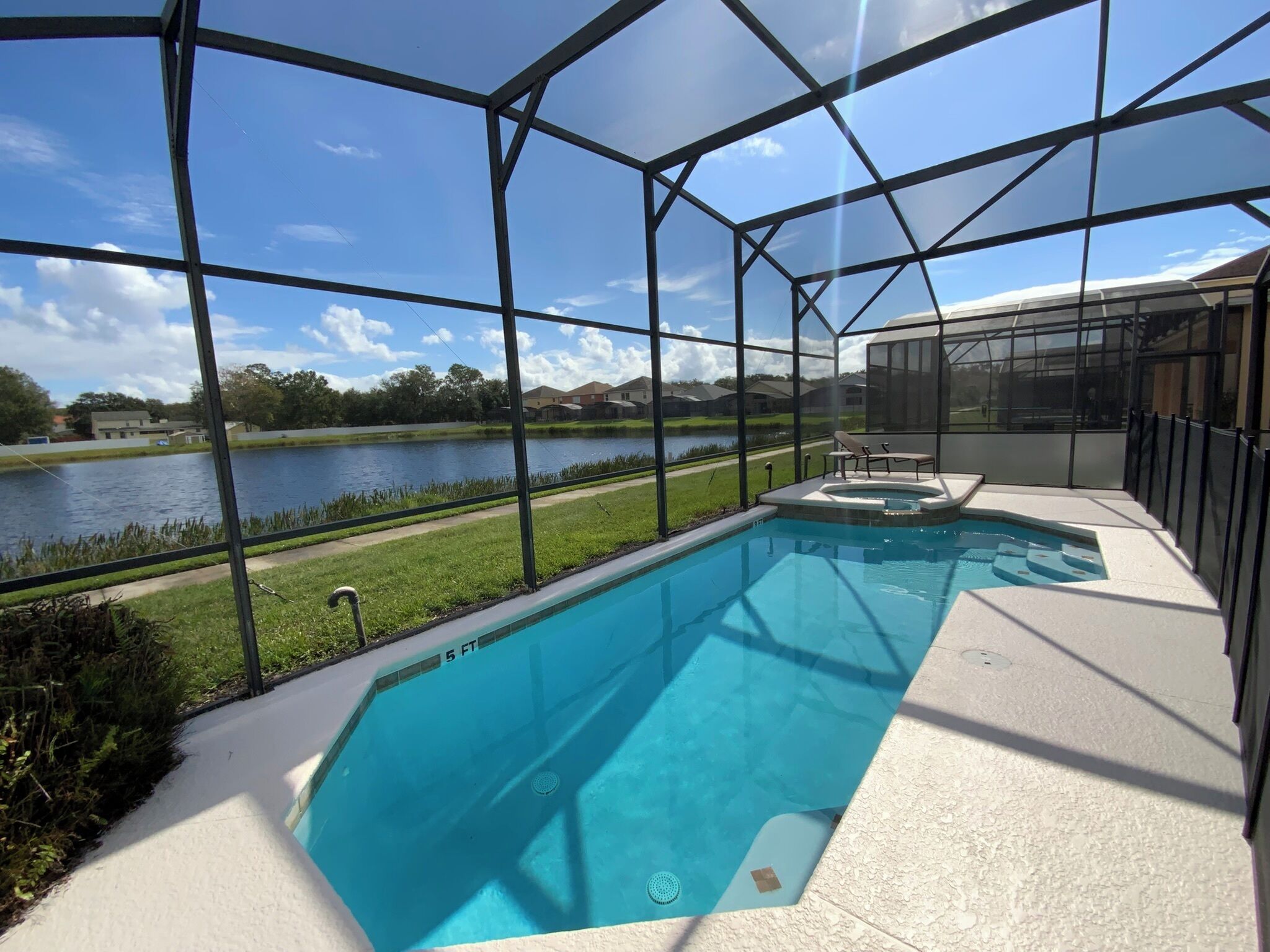 A swimming pool with a view of a lake and houses in the background.