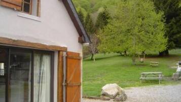 Situated in a serene natural setting, this charming building features a simple design with a sloped roof and a traditional chimney.