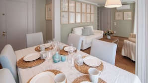 A dining area with a table set for six, surrounded by sofas and a decorative wall. - Charming 4 bedrooms Apartment with Amazing Terrace and Fairytale Garden (Venezia)