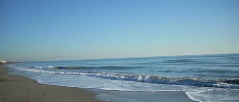 A beach with a clear sky and calm sea.