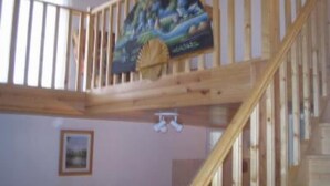 Una escalera de madera que lleva a un balcón con una vista pintoresca.