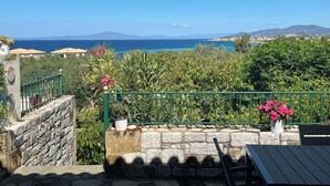 Un escalier en pierre menant à une terrasse d’où l’on peut admirer la mer et les montagnes.