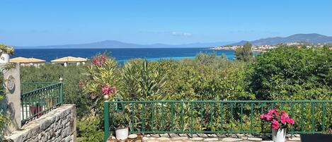 Una escalera de piedra que conduce a una terraza con vistas al mar y a las montañas.