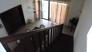 A room with a dining table, chairs, a TV, and a staircase. - Your own villa with private pool in tropical garden.  (Grand Baie)