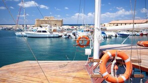 Un puerto deportivo con barcos amarrados, una cubierta de madera y un flotador salvavidas.