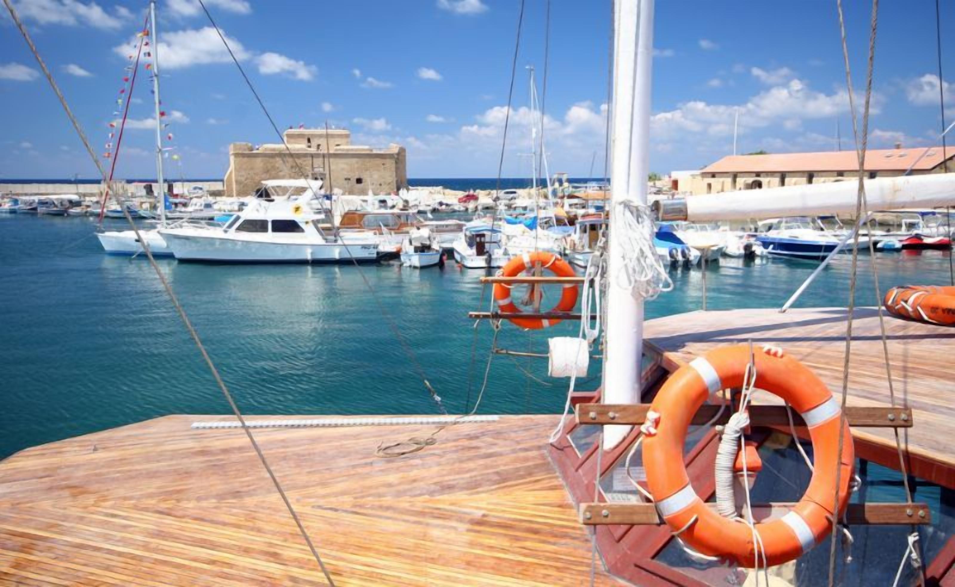 Un port de plaisance avec des bateaux amarrés, une terrasse en bois et une bouée de sauvetage.