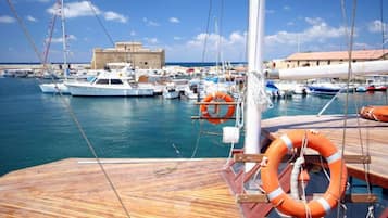 Un port de plaisance avec des bateaux amarrés, une terrasse en bois et une bouée de sauvetage.