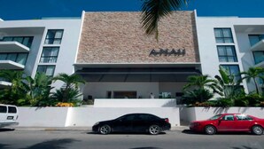 A modern hotel with a stone facade and multiple windows. - Luxury Condo, Roof Top Swimming Pool (Playa del Carmen)