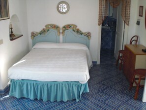 Ein Schlafzimmer mit einem Bett, einem Holztisch und einem gestreiftem Boden.