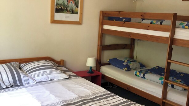 A dormitory room with bunk beds, a single bed, a framed picture on the wall, and a red lamp on a side table. - Apartment/ flat - Capbreton (Capbreton)