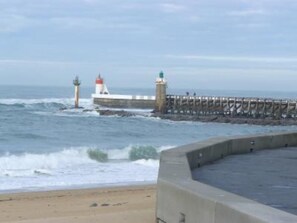 A coastal scene with a lighthouse and pier.