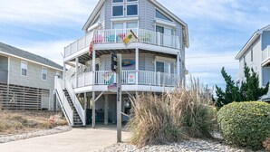 A multi-story building with balconies, a sign for 'Key to Paradise', and a beachside location. - Key to Paradise - Kitty Hawk MP 4, Pool, Hot Tub, Excellent Ocean View, Easy Beach Access (Kitty Hawk)