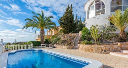 Perinteinen espanjalainen talo, jossa on uima-allas ja merenranta.