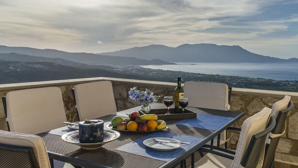 Ein Tisch für zwei Personen mit Blick auf das Meer und die Berge.