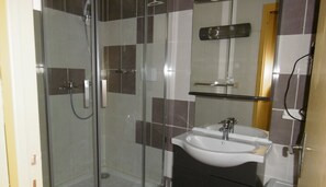 Regadera, secadora de cabello, papel de baño 