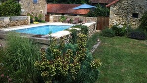 A stone house with a swimming pool, surrounded by lush greenery and a wooden fence. - La Boissière: Peaceful vacations in Périgord Noir (Saint Chamassy)
