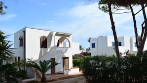 Un edificio blanco con ventanas de arco y una escalera que conduce a la entrada.