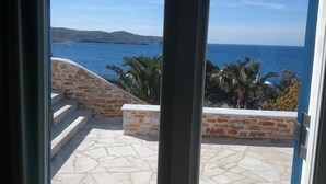 Eine Steinterrasse mit Blick auf das Meer und die Hügel.