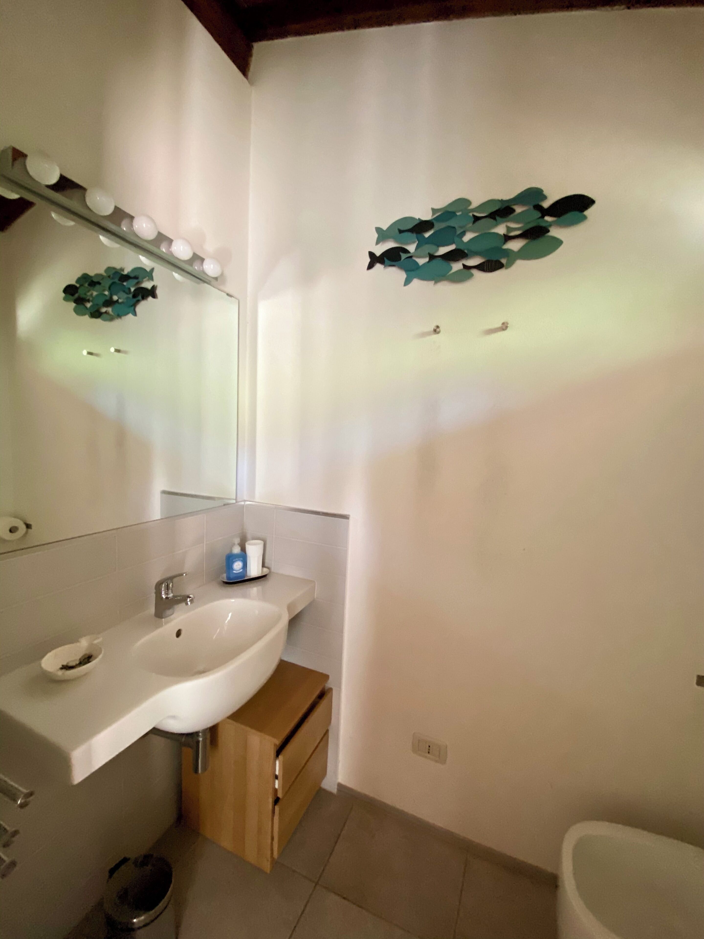 Een badkamer met een wastafel, spiegel en toilet.