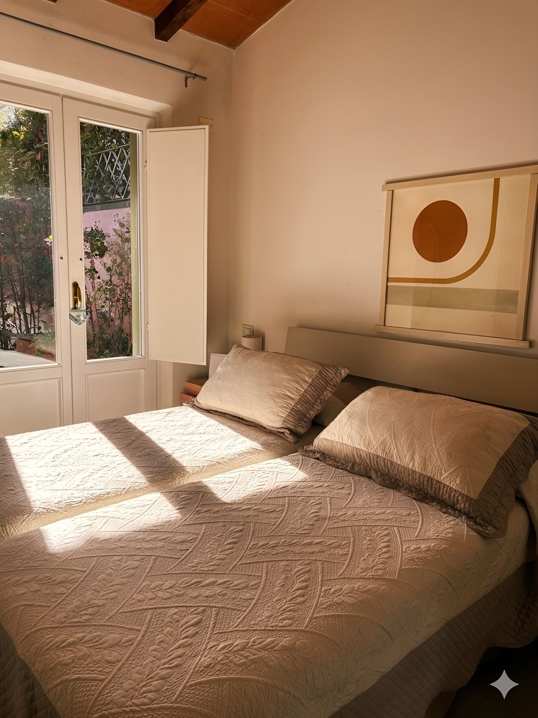 Une chambre à coucher avec un lit, une fenêtre et une œuvre d’art accrochée au mur.