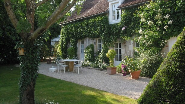 A house with a gravel driveway, a white table and chairs, and potted plants. - Beautiful cottage with pool , LOIRE VALLEY close to ORLEANS .1 hour from Paris . (Saint-Jean-De-Braye)