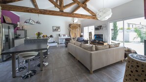 Een moderne keuken met een eethoek, een bank en een televisie.