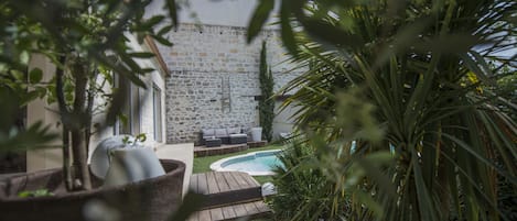 A stone building with a pool and outdoor seating.
