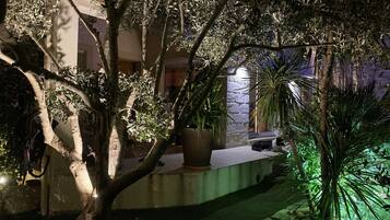 Stroll through the tranquil garden, surrounded by lush trees and plants, and enjoy a peaceful evening under the stars.