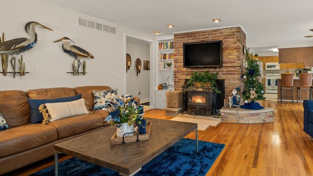 A living room with a fireplace, a sofa, a coffee table, and decorative items. - Heron Pointe... where nature and luxury combine for an unforgettable experience! (White Lake)