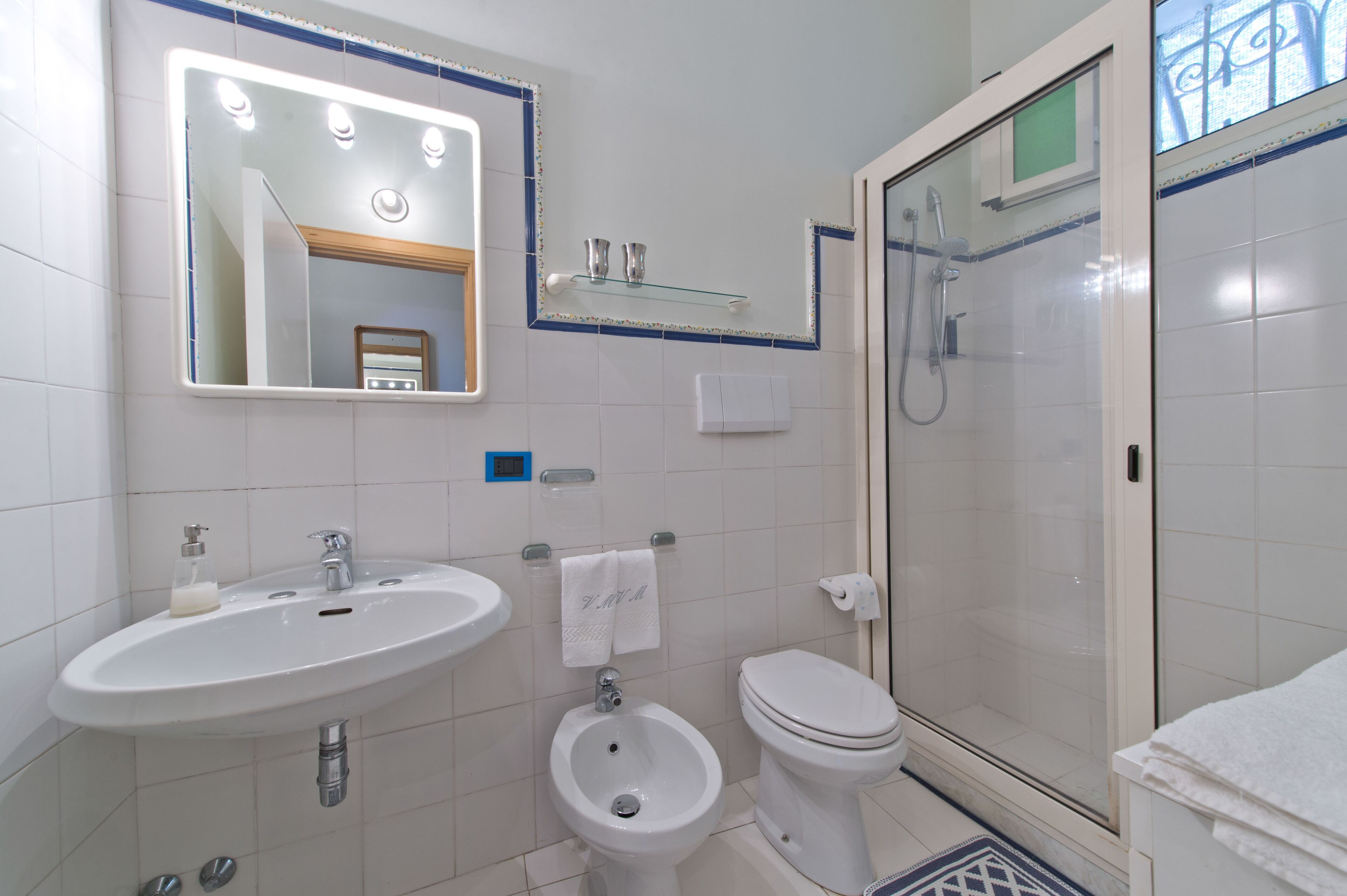 Ein Badezimmer mit Waschbecken, Bidet, Toilette und einer Duschkabine.