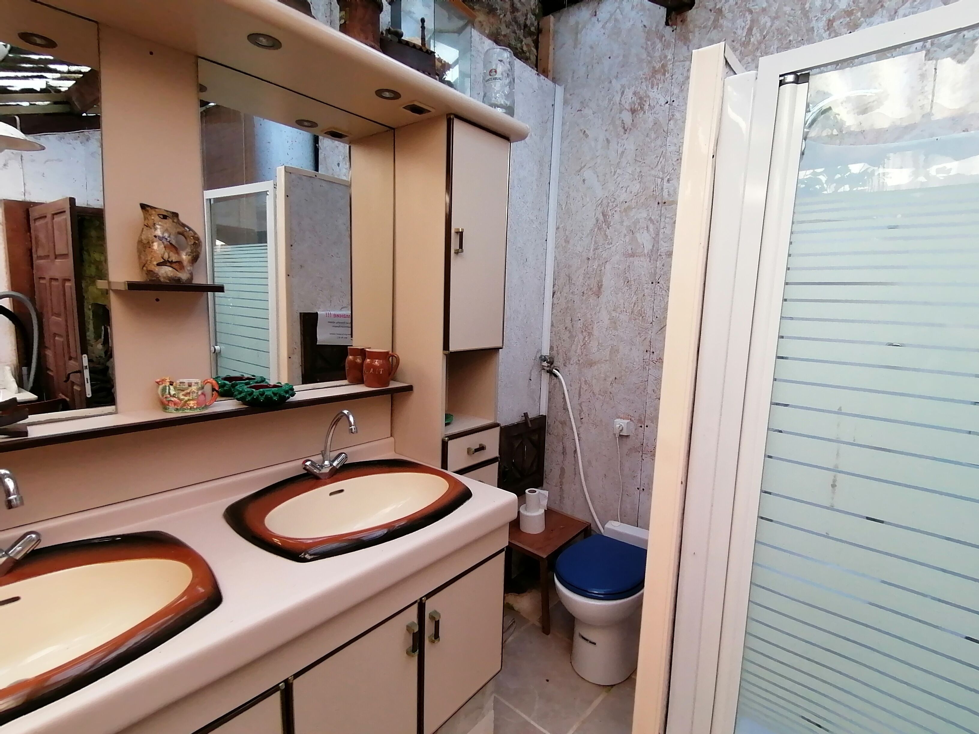 Une petite salle de bain avec deux lavabos, un miroir et des toilettes.